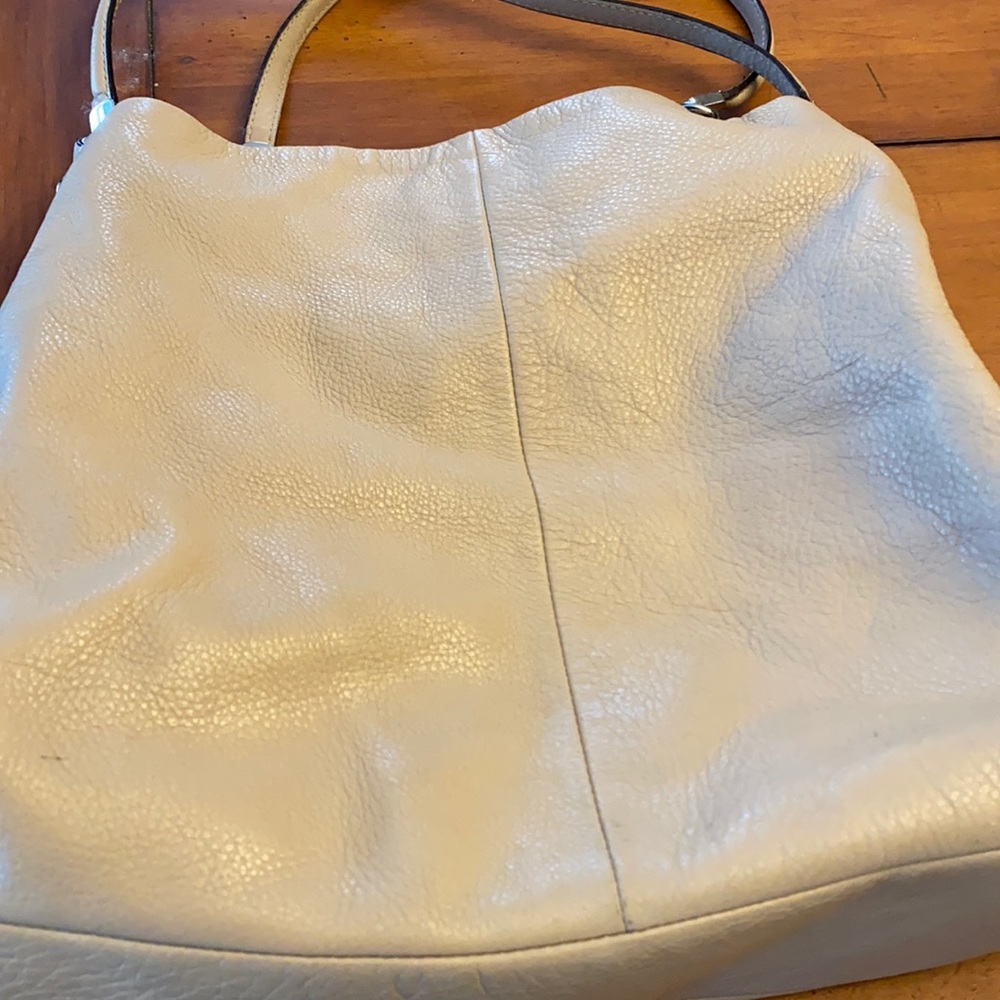 Beige Authentic Coach purse with 3 inside pockets.